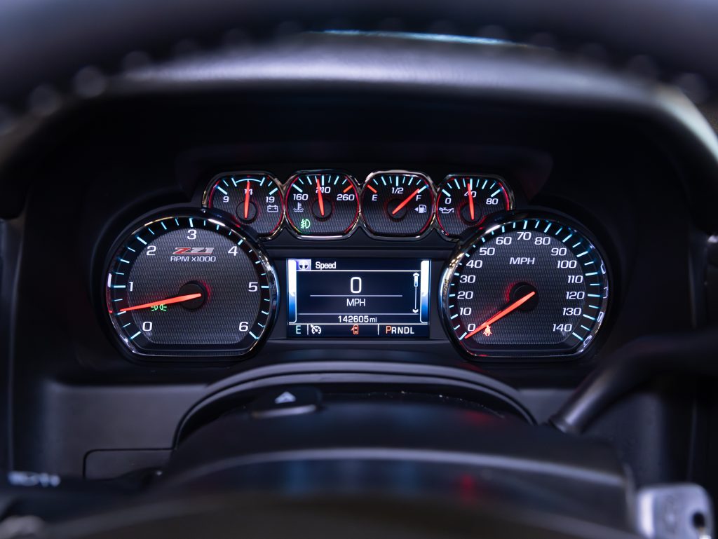 Close-up of a car dashboard showing tachometer, speedometer, and fuel gauge. The speedometer reads 0 MPH, and the odometer displays 142805 miles. - Monarch Showroom