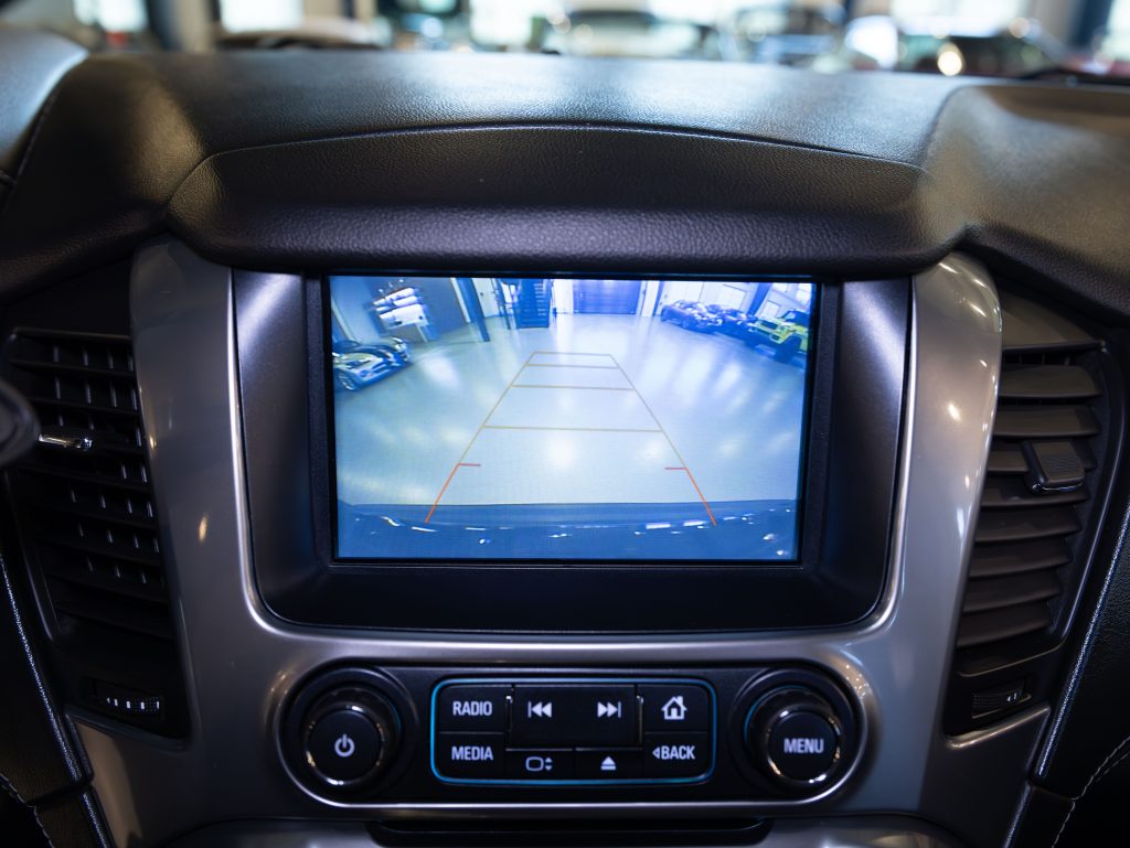 Car dashboard display showing a rearview camera image with parking guidelines. - Monarch Showroom