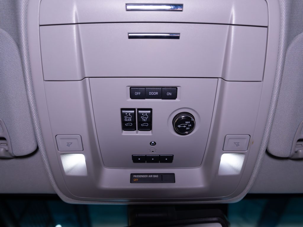 Interior view of a car's overhead console featuring light controls, airbag indicator, and a sunglasses compartment. - Monarch Showroom