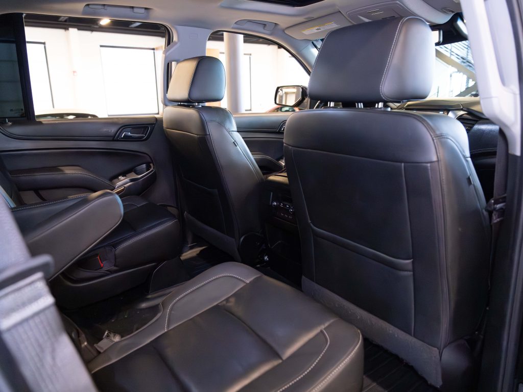 Interior of a car showing black leather seats, including a rear bench and two front seats, with a view of the dashboard area. - Monarch Showroom